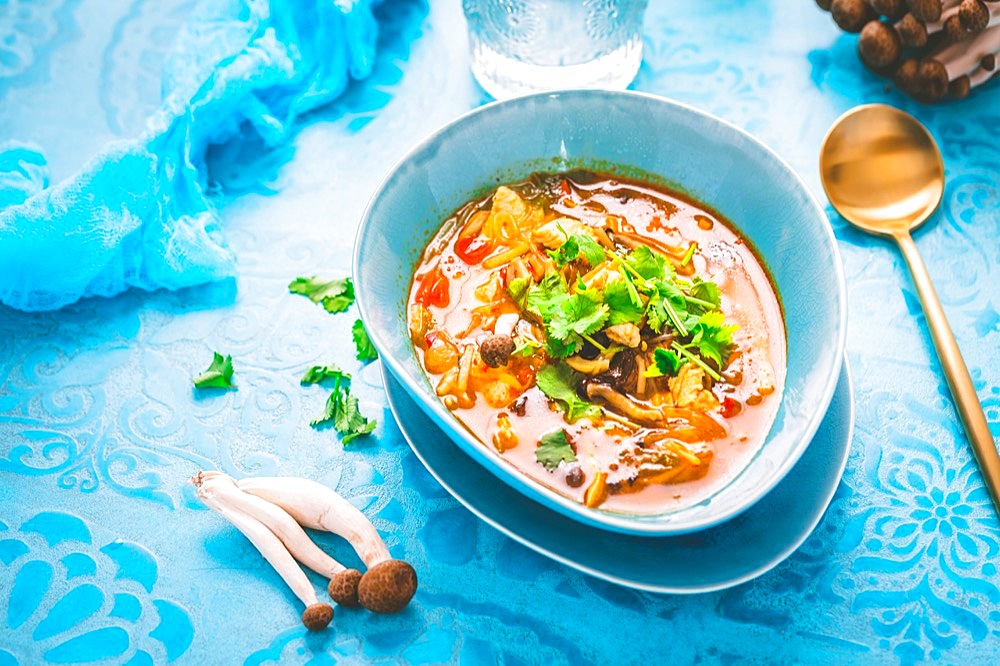 Thai chicken red curry. Thailand tradition red curry soup with chicken, mushrooms and coconut milk on blue background