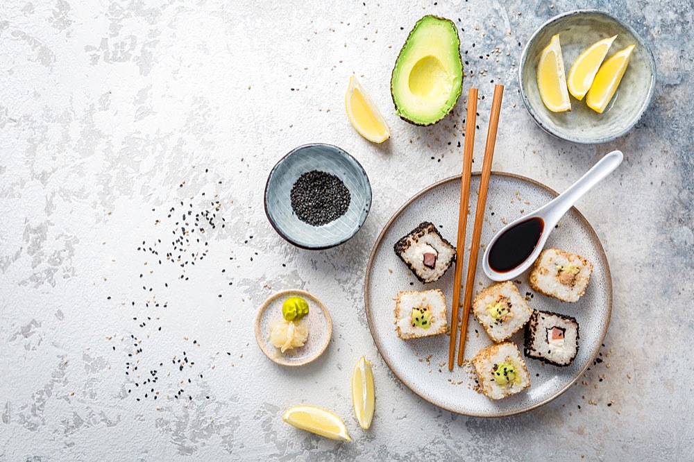 Tuna and avocado sushi wrapped in sesame seeds with ingredients