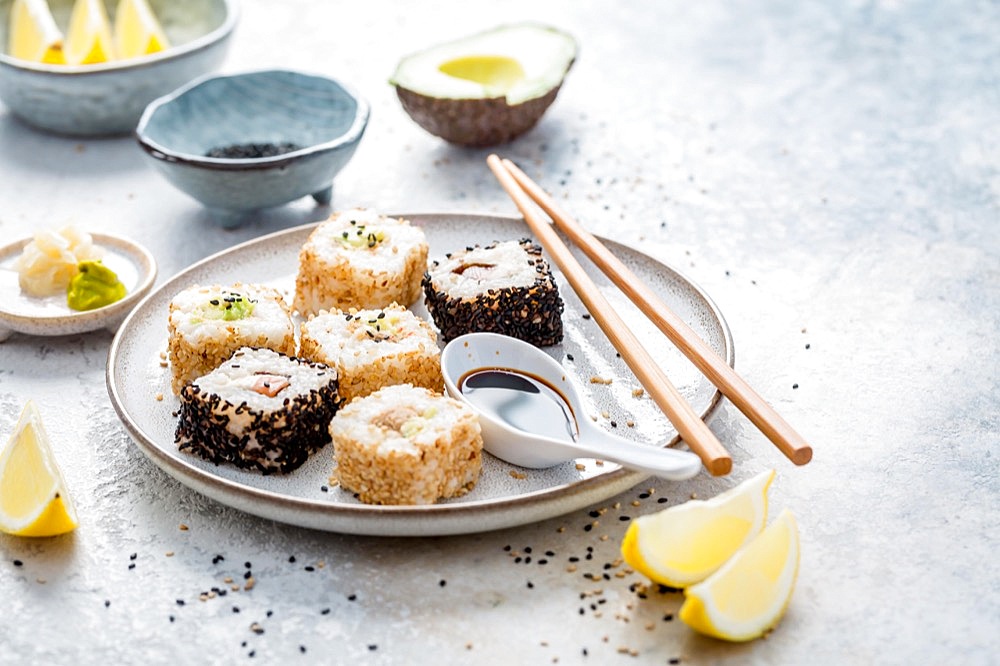 Tuna and avocado sushi wrapped in sesame seeds with ingredients