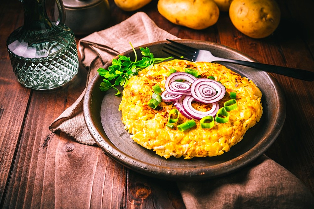 Tortilla - spanish omelette with potatoes and onions on wooden background