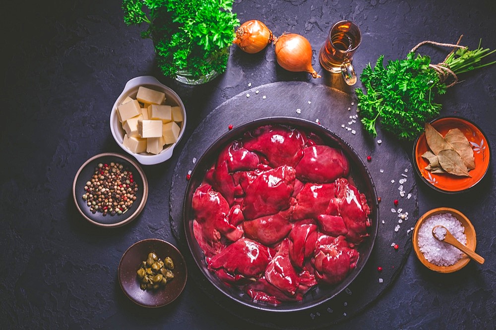 Raw chicken liver with cooking ingredients for liver pate, herbs and brandy