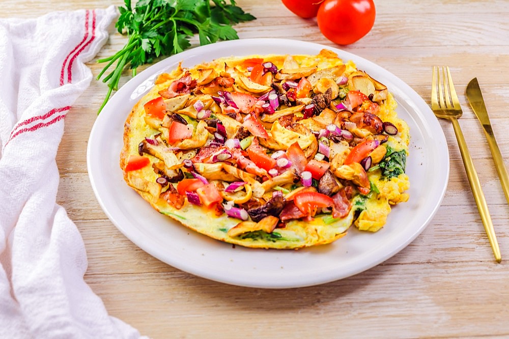 Vegetarian omelette or frittata with herbs, mushrooms, tomatoes and onion