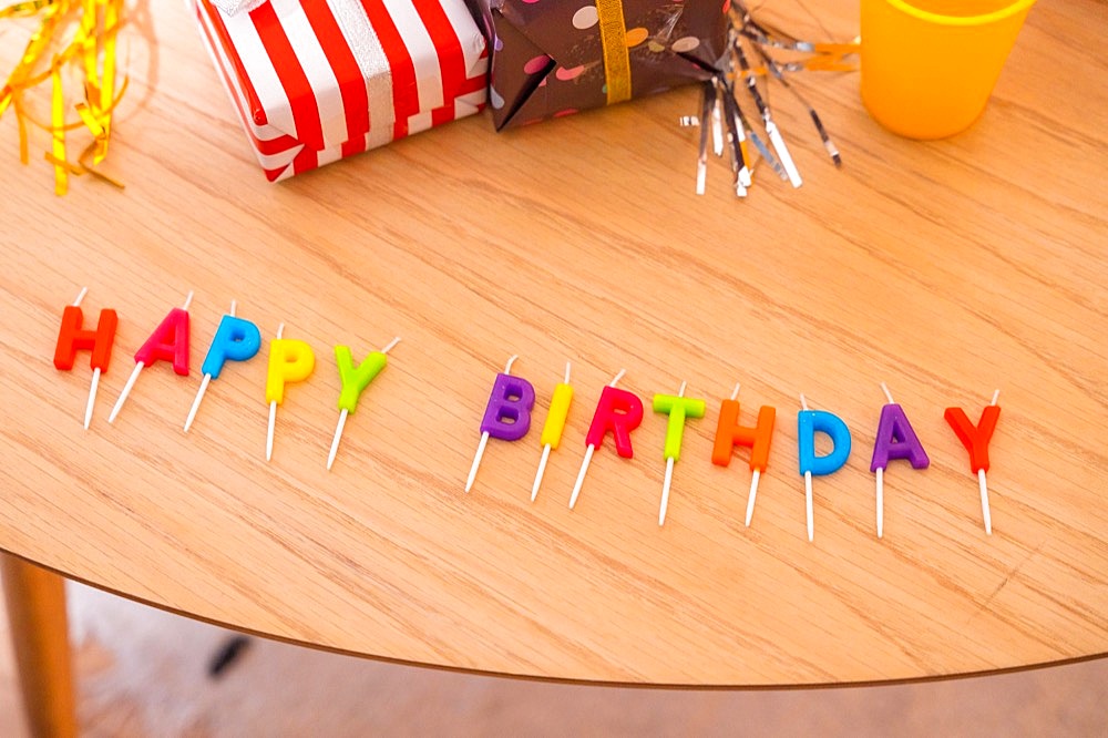 Happy birthday lettering on the table at a friends birthday party with gifts