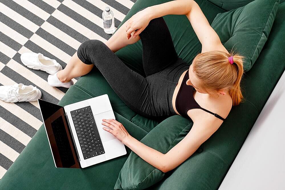 Active young woman in sportswear using laptop, view from above