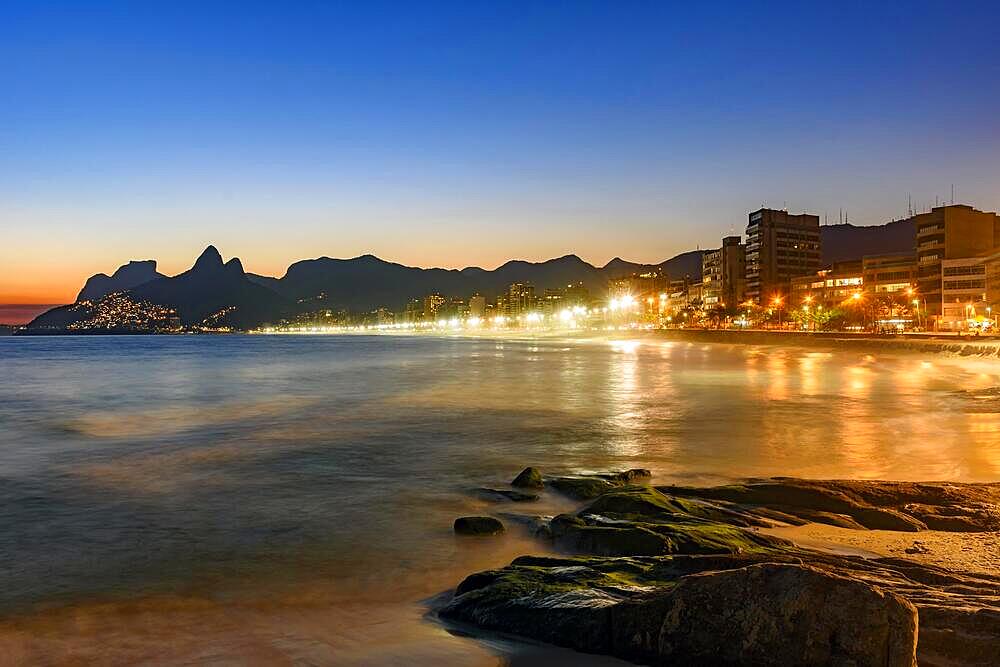 Ipanema beach with beautiful skyline and sunset. City lights and buildins araoud the ocean, Pedra do Arpoador, Ipanema, Rio de Janeiro, Rio de Janeiro, Brasil