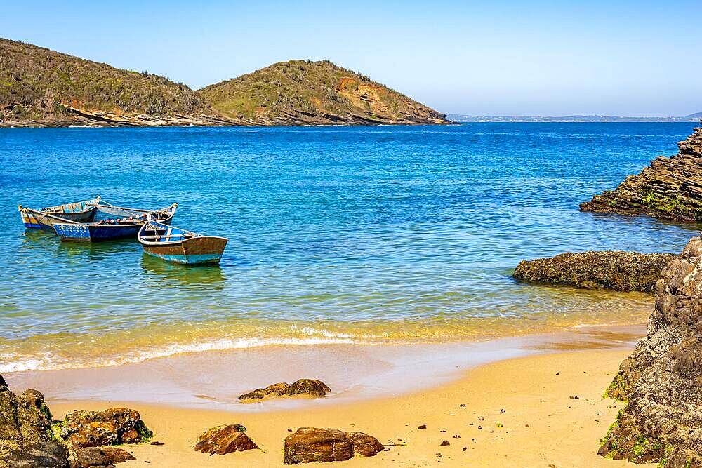 Old wooden fishing boat floating on the colorful and transparent waters of the sea of Buzios in the state of Rio de Janeiro, Brazil, Brasil, South America