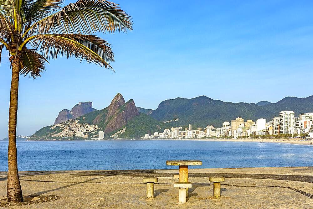 View of Ipanema beach in Rio de Janeiro on a summer morning with rocks, palm tree, ocean and buildings, Brasil