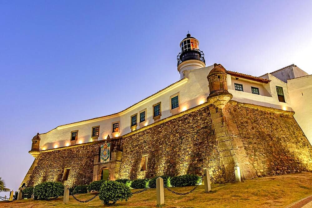 Facade and stone wall of the old and historic fort and lighthouse Barra during sunset in the city of Salvador, Bahia, Brasil