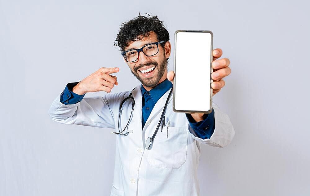 Happy doctor showing cell phone screen to camera. Smiling doctor showing cell phone screen pointing finger isolated