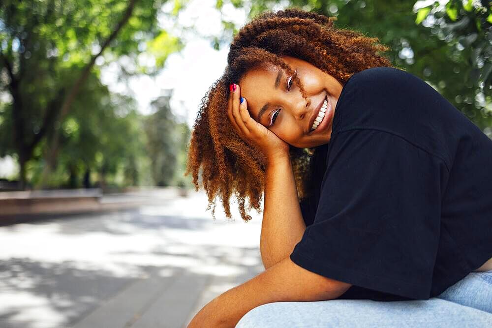 Close up photo of wavy hairdo charming cheerful dark skin person have good mood nice sightseeing weekend outdoors