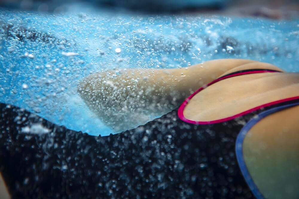 Young woman on Swimming Background. Female dressed in swimwear, swim in sport club and performing water activities