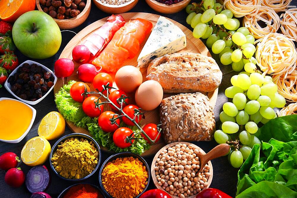 Composition with assorted organic food products on wooden kitchen table