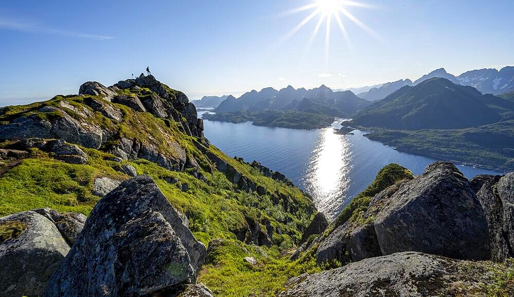 Hikers at the top of Dronningsvarden or Stortinden, view of Fjord Raftsund and mountains, Sun Star, Vesteralen, Norway, Europe