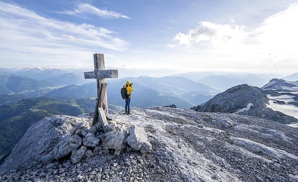 Mountaineer at a secondary peak of the Hochkoenig with summit cross, photographed, view of mountain panorama, Berchtesgaden Alps, Salzburger Land, Austria, Europe