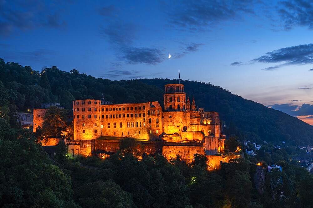 The illuminated castle of the city of Heidelberg at blue hour, the moon is in the sky, Heidelberg, Baden-Wuerttemberg, Germany, Europe