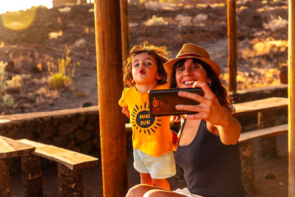 Portrait of mother and son on vacation at Tacoron beach on El Hierro, Canary Islands. taking a selfie