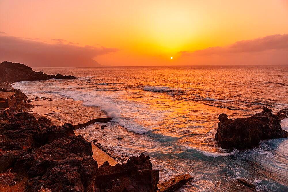 Wonderful orange sunset in the Natural Pools of La Maceta in El Hierro en la Frontera, Canary Islands