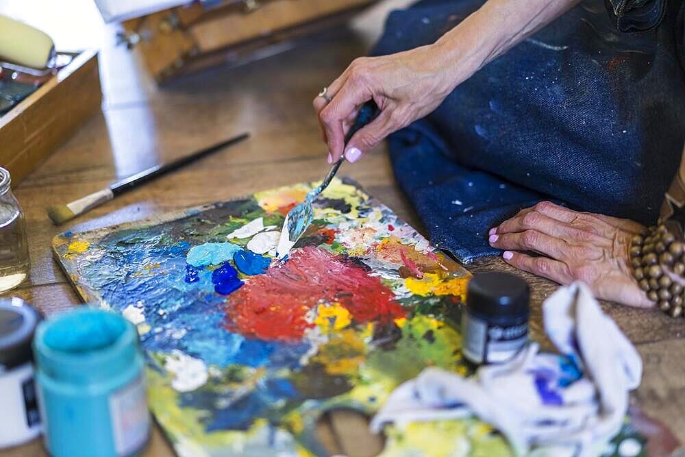 Close up of a woman making colors on a pallete