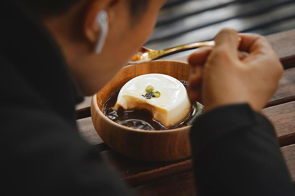 Man eating delicious tofu pudding