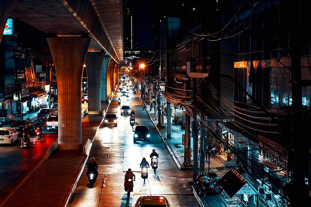 BANGKOK, THAILAND - APRIL 10, 2019: Cars and motorbikes on night illuminated road