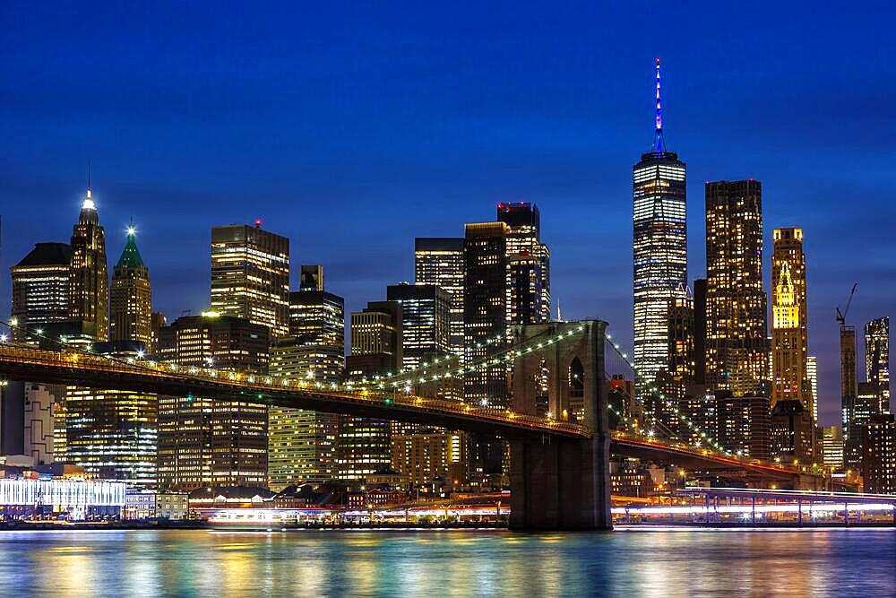 New York City skyline of Manhattan with Brooklyn Bridge and World Trade Center skyscraper at night in New York, USA, North America