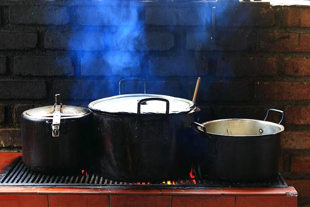 Three cooking pots on a cooker in an open-air kitchen, Colombia, South America