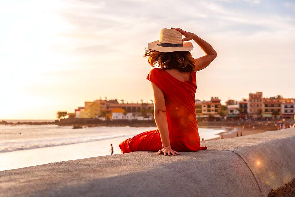 Tourist woman at sunset enjoying vacations on the beach of Valle Gran Rey village in La Gomera, Canary Islands