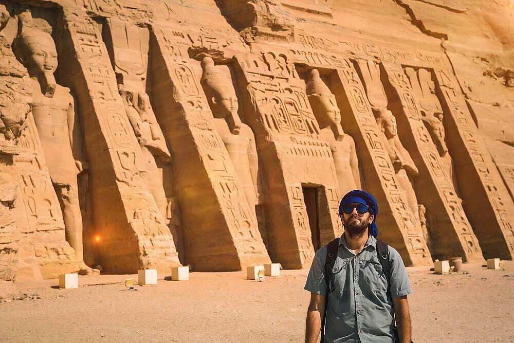 A young man wearing a blue turban visiting the Egyptian Temple of Nefertari near Abu Simbel in southern Egypt in Nubia next to Lake Nasser. Temple of Pharaoh Ramses II, travel lifestyle