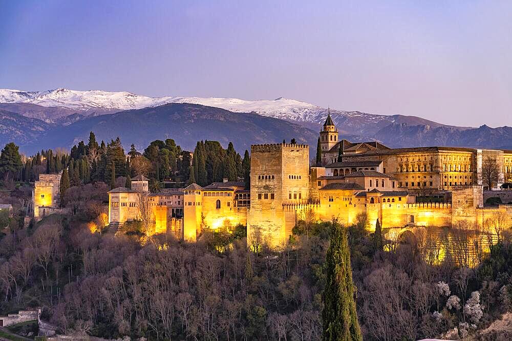 View from the Mirador de San Nicolas of Alhambra and the snow-capped mountains of the Sierra Nevada at dusk, Granada, Andalucia, Spain, Europe