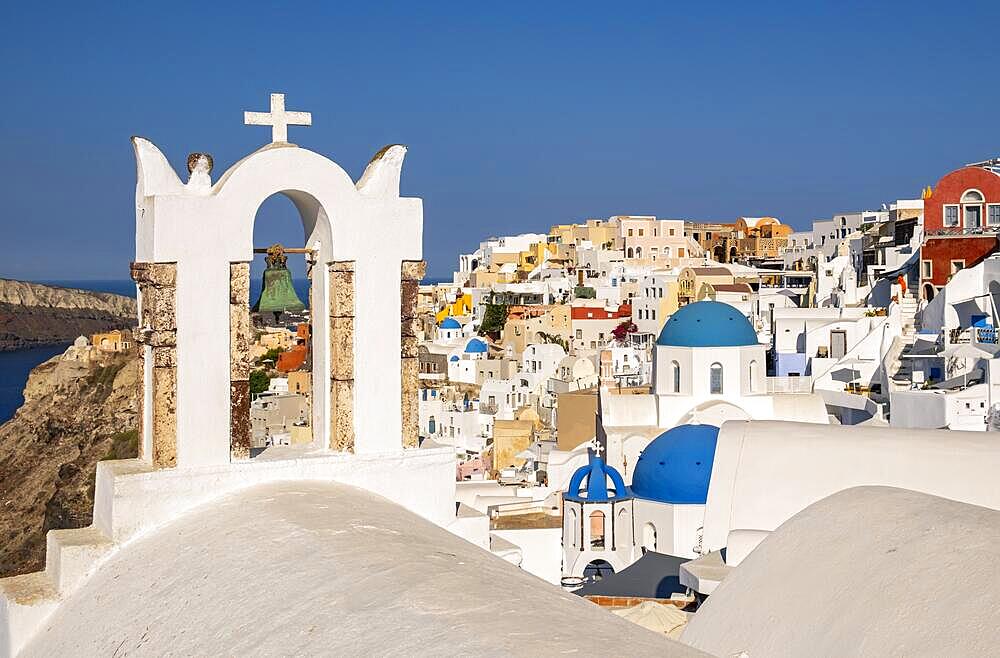 White belfry of Chapel of Saint John the Baptist and village of Ia, Oia, Santorini, Greece, Europe