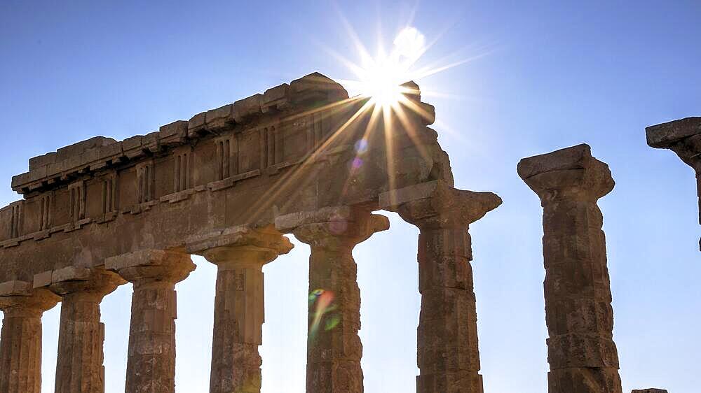 Column row, chapter, entablature, backlight shot, sun as star, sun over entablature, temple C, Apollo temple, Selinunte, archaeological site, temple, southwest Sicily, Sicily, Italy, Europe