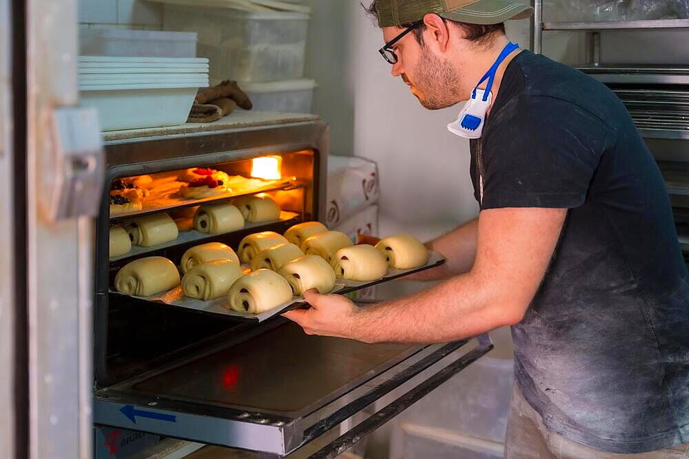 Baker of bakery in workshop workshop of artisan bakery preparing croissant and neapolitan for baking