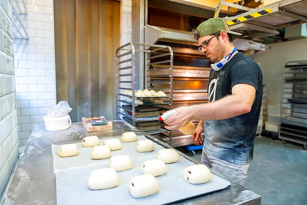 Baker of bakery in workshop workshop of artisan bakery preparing croissant and neapolitan