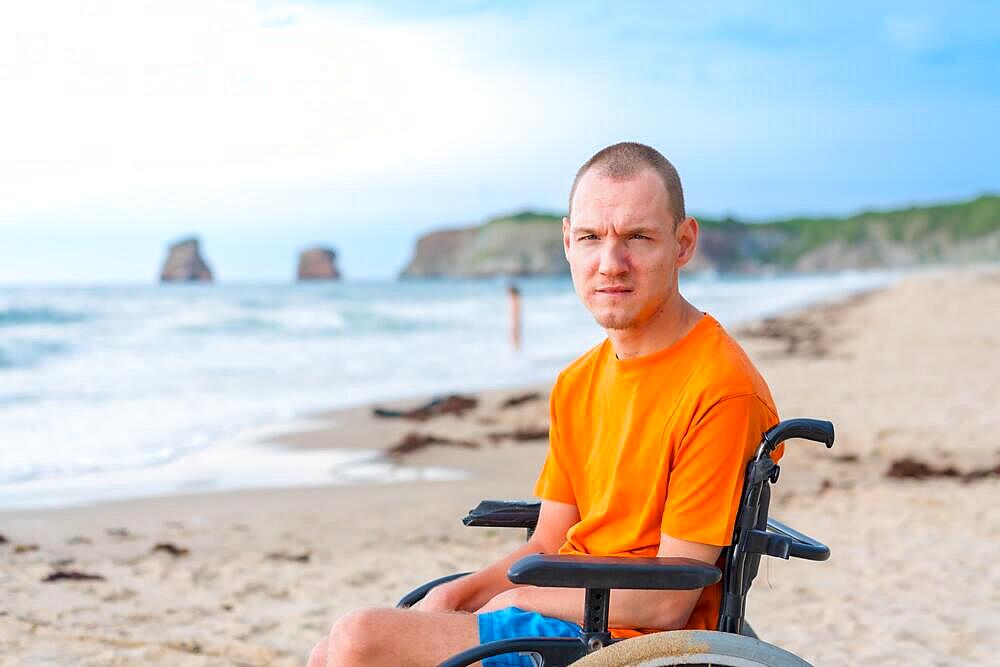 Portrait a disabled person in a wheelchair on the beach enjoying nature