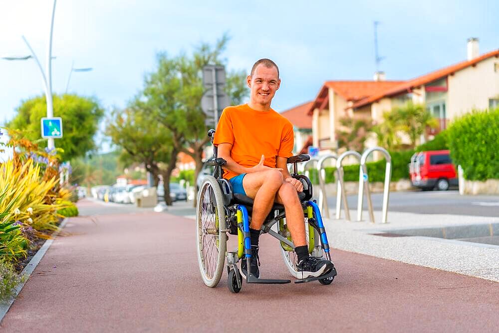 Portrait of a very cheerful disabled person in a wheelchair on vacation in the city