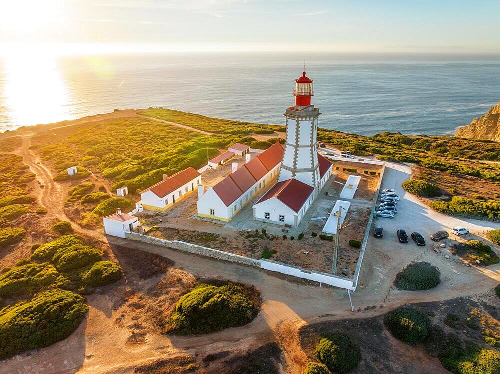 Aerial drone view of lighthouse on Cabo Espichel cape Espichel on Atlantic ocean at sunset. Sesimbra, Portugal, Europe