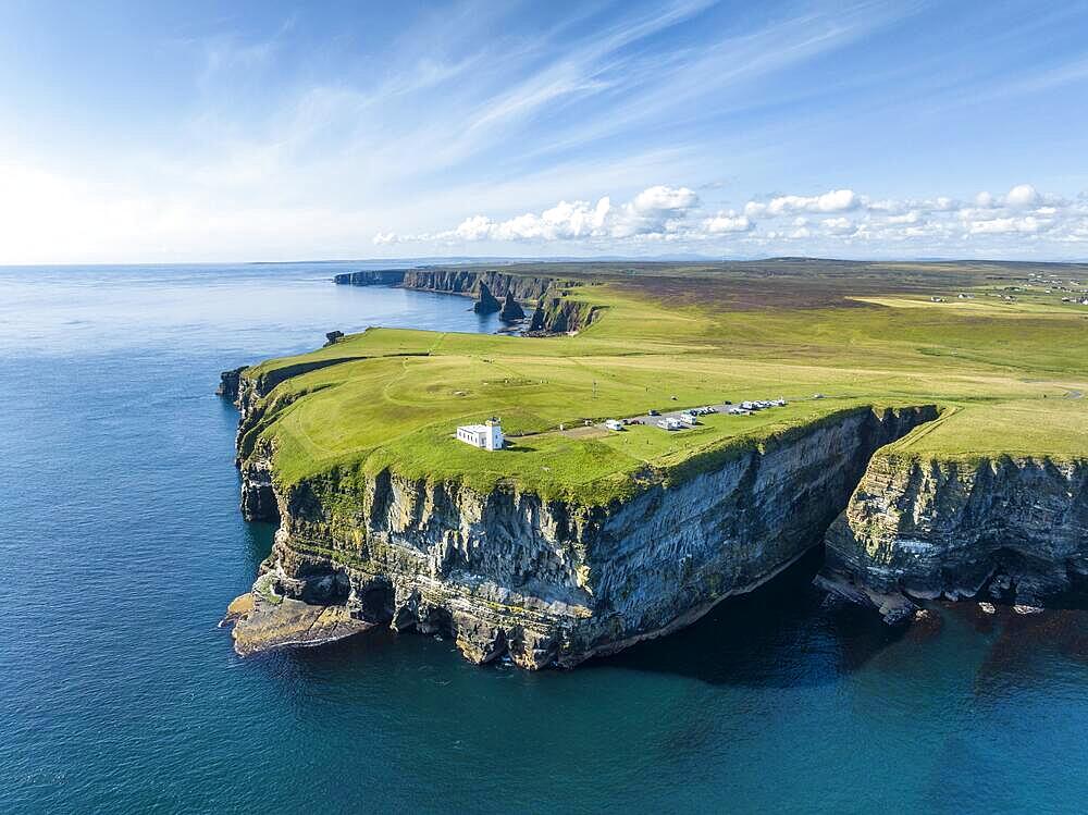 Aerial view of the rugged coastal landscape at Duncansby Head with the lighthouse and the Duncansby Stacks rock formation behind, Scotland's north-eastern point, County Caithness, Scotland, United Kingdom, Europe