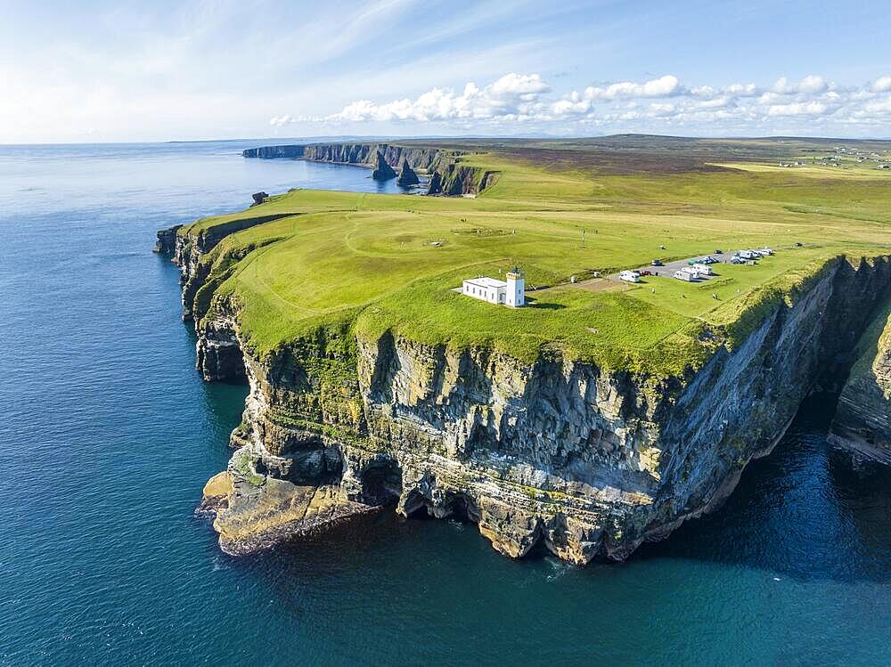 Aerial view of the rugged coastal landscape at Duncansby Head with the lighthouse and the Duncansby Stacks rock formation behind, Scotland's north-eastern point, County Caithness, Scotland, United Kingdom, Europe