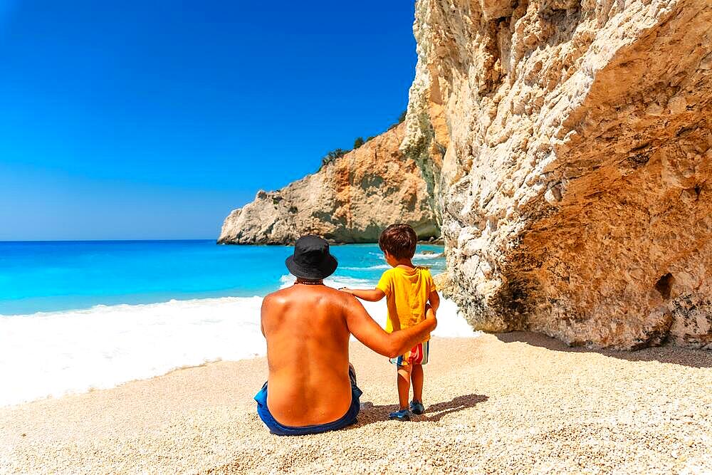 A father and child having fun on Porto Katsiki beach in summer vacation Lefkada island, Greece, Europe