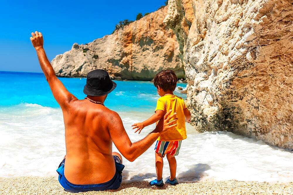 A father and child having fun on Porto Katsiki beach in summer vacation Lefkada island, Greece, Europe