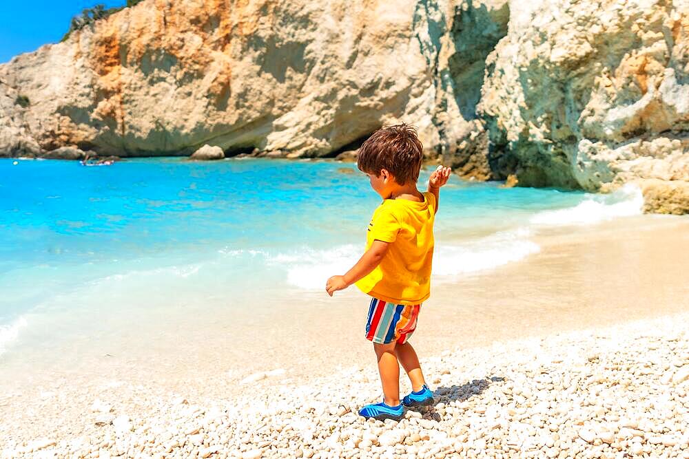 Boy having fun on Porto Katsiki beach in summer vacation Lefkada island, Greece, Europe