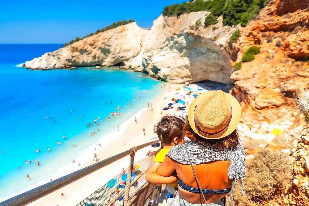 Woman walking down the stairs leading to Porto Katsiki beach on Lefkada island in summer, Greece, Europe