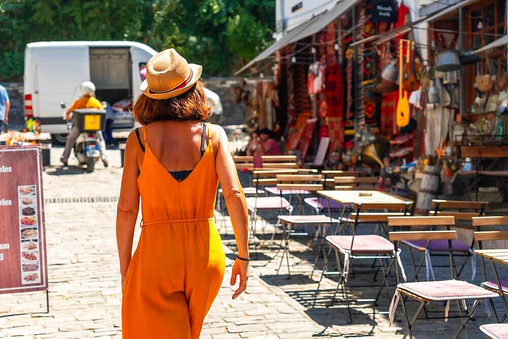 A tourist woman visiting the city of Gjirokaster or Gjirokastra, restaurant area. Albanian