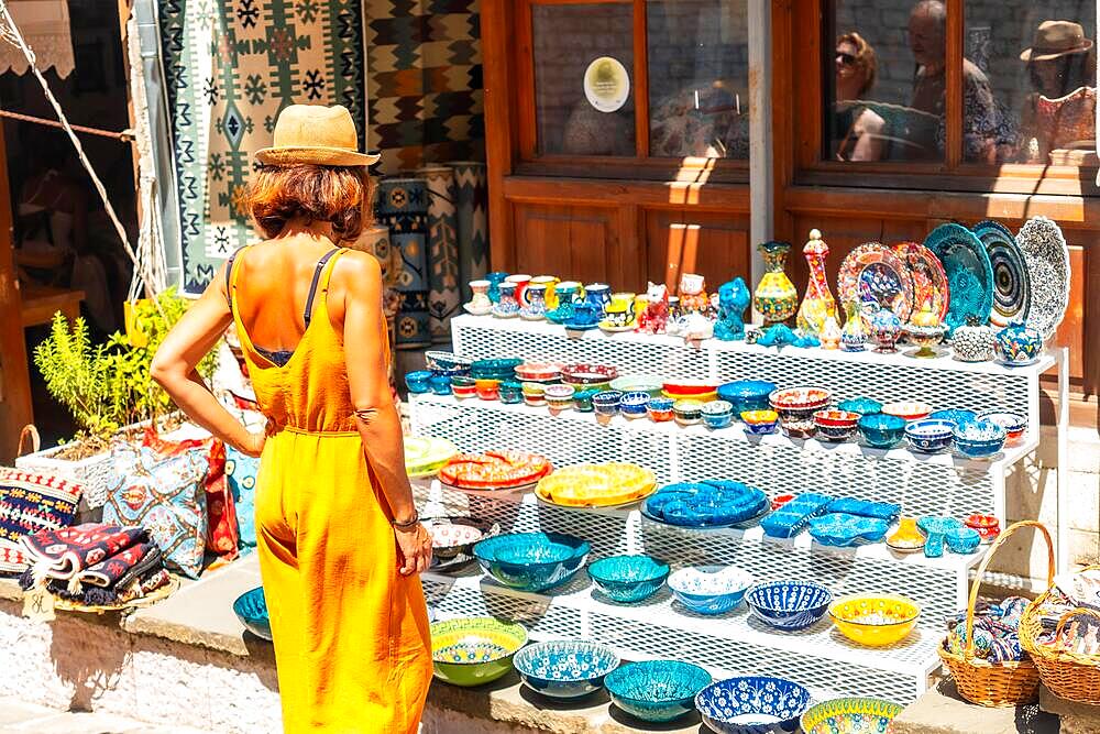 A tourist woman visiting the city of Gjirokaster or Gjirokastra, area of restaurants and souvenirs. Albanian