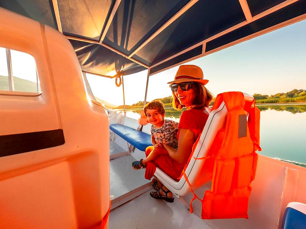 Mother with her son on a boat on a tourist excursion on Lake Shkoder in Shiroka. Albania