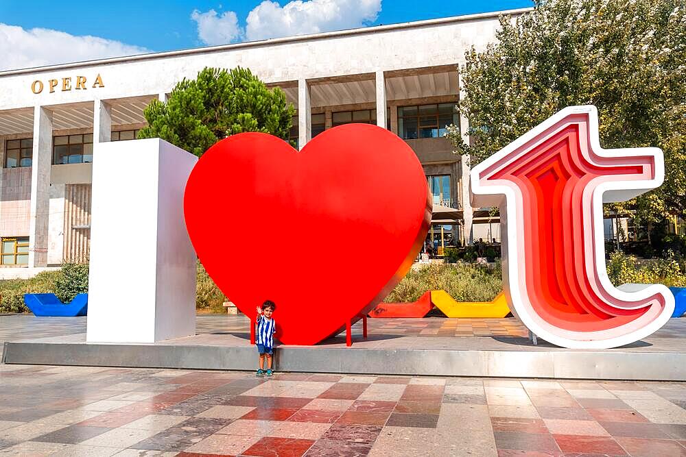 Portrait of a child in the I Love Tirana sculpture at Skanderbeg Square in Tirana reflected. Albania