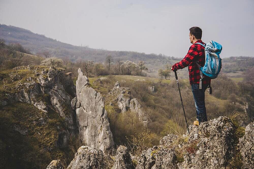 Side view rambler with backpack enjoying nature