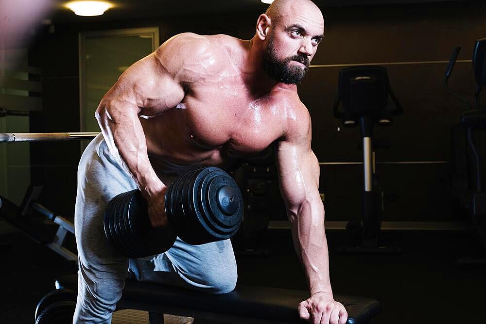 Bald man leaning bench