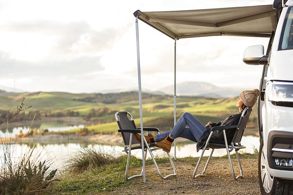 Front view road trip car lake with woman relaxing