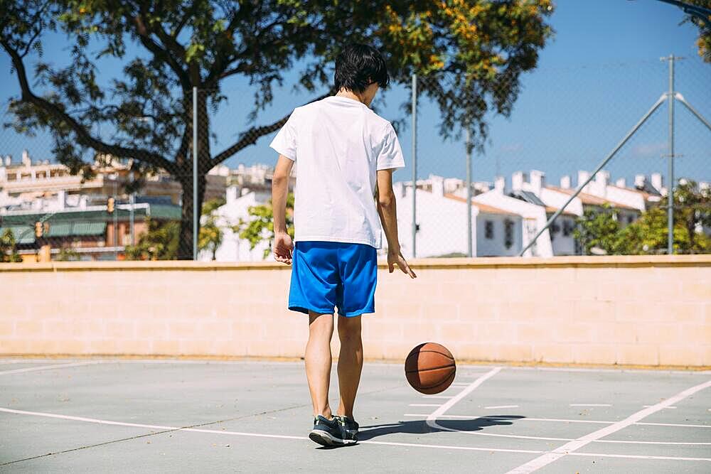 Teenager playing with ball court